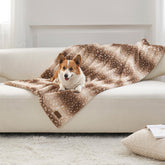 Manta COZY KISS con estampado de ciervo navideño protege el sofá de pelos de mascotas.