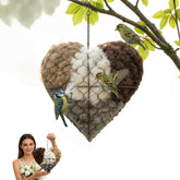 Corazón-nido de alpaca hecho a mano colgado en exterior; atrae aves pequeñas con fibra natural.