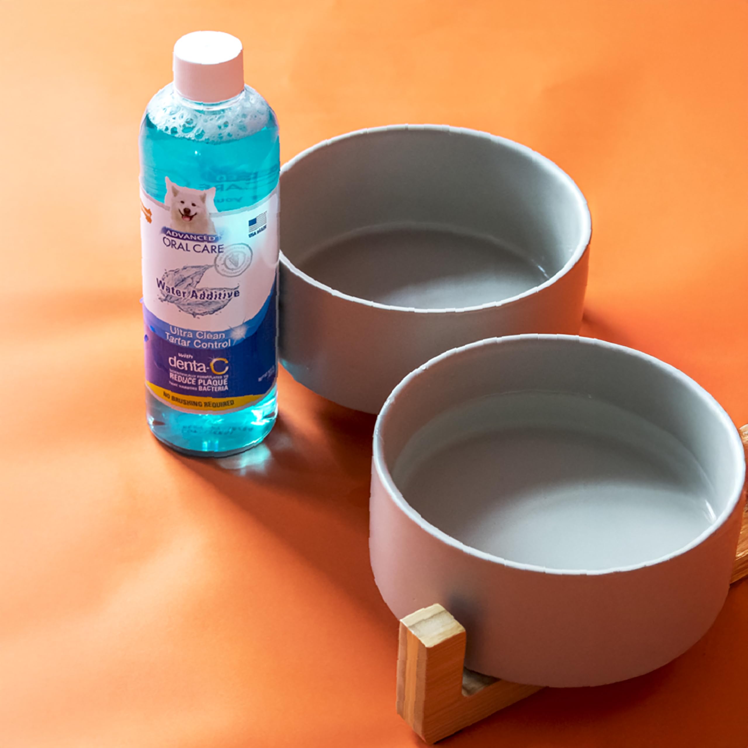 Cucharada de aditivo dental Nylabone añadida al agua del perro